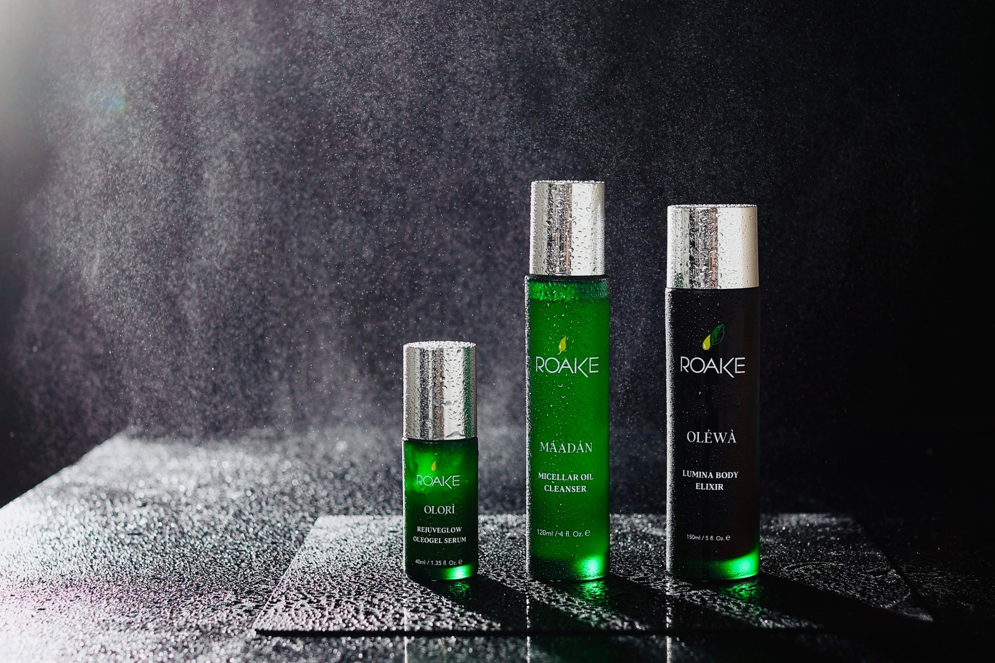 Three Roake skincare products on a textured surface with a dark background