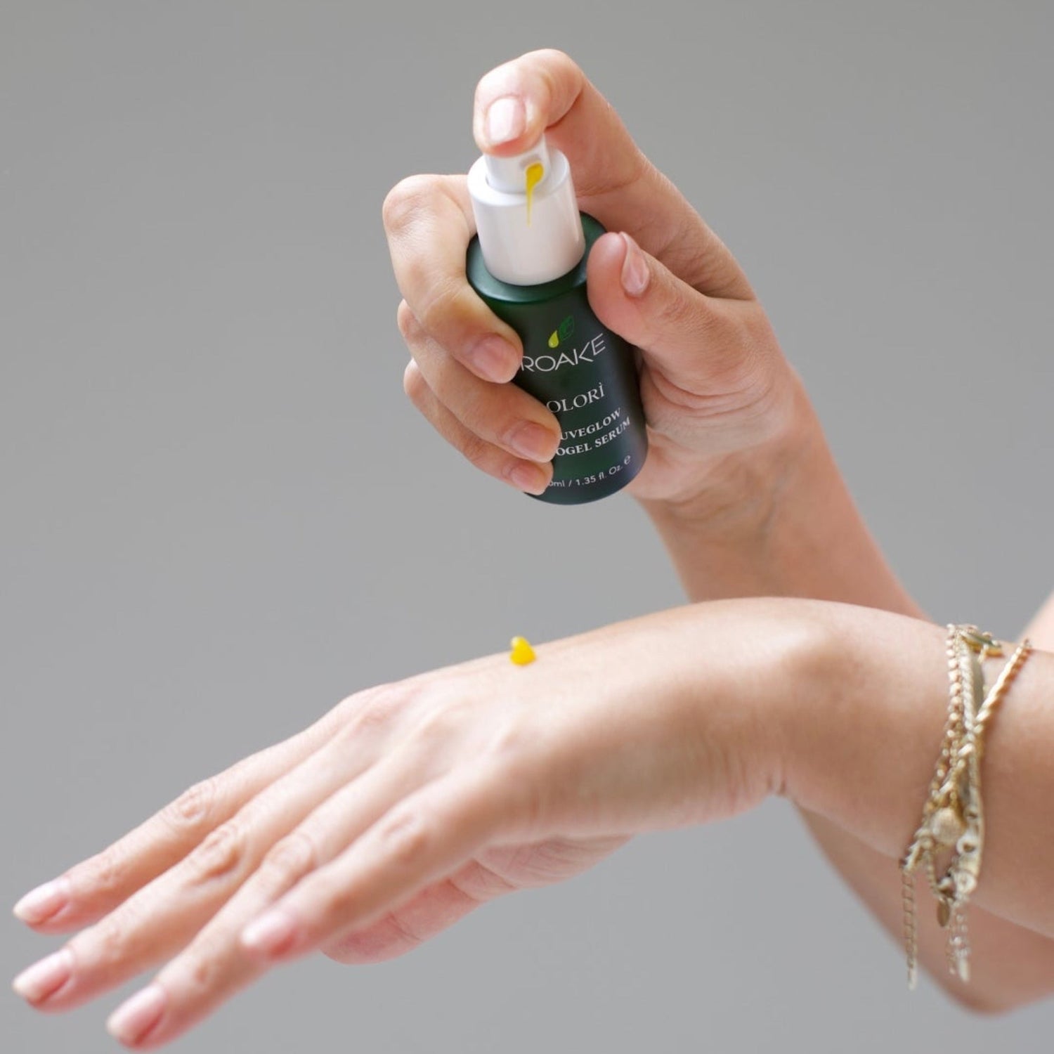A drop of Olorì RejuveGlow Serum on the back of a woman’s hand