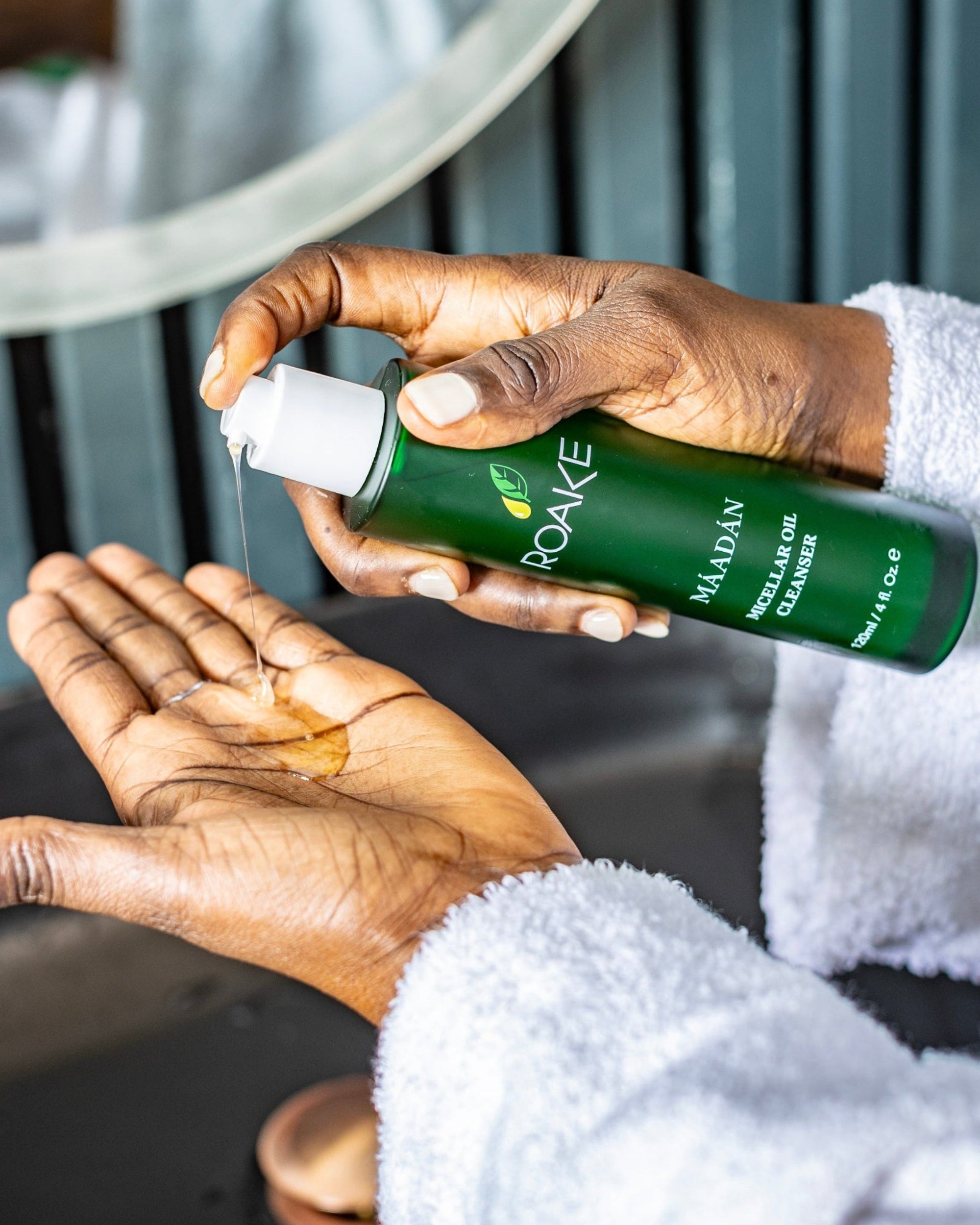 Woman dispensing Máadán Micellar Oil Cleanser onto palm – silky oil-to-milk formula for a nourishing cleanse